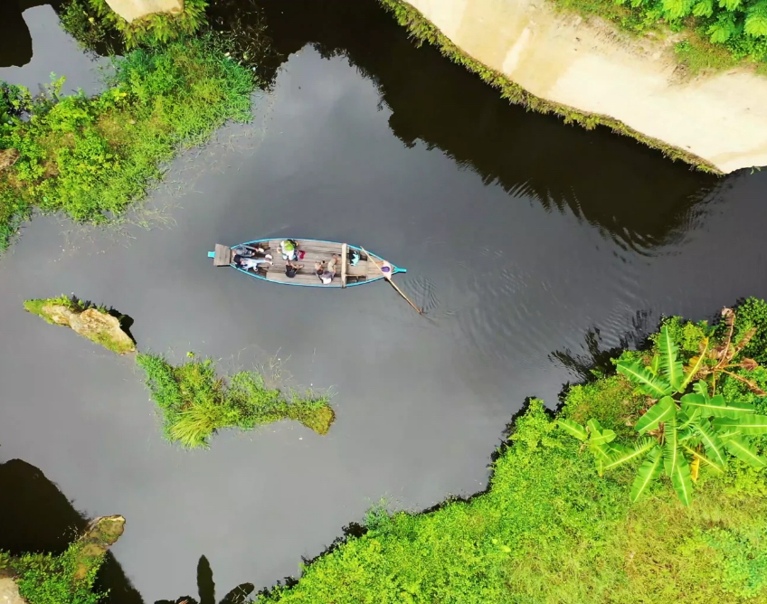 Birdseye view of a small boat gently being rowed along a river