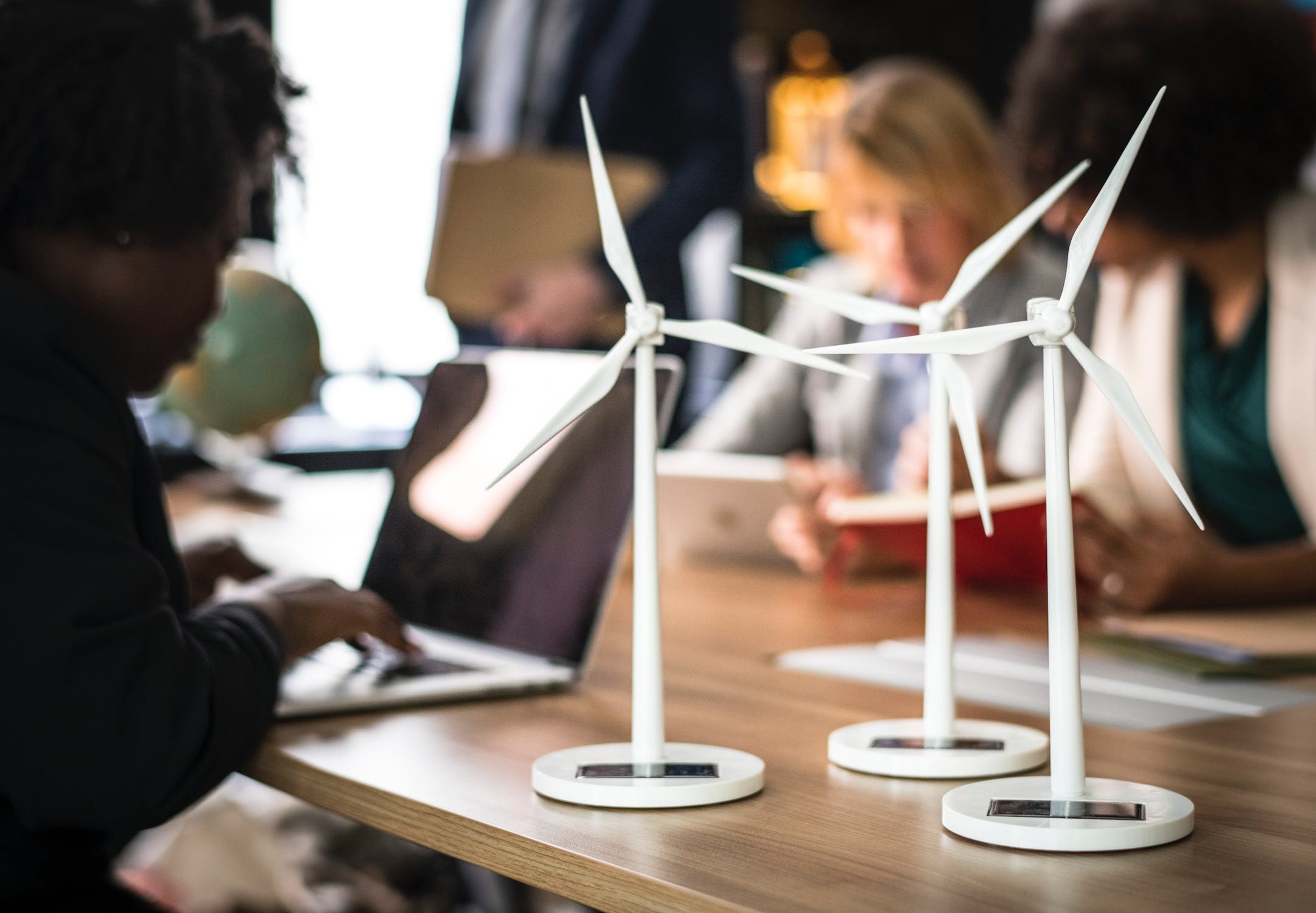 Small renewable wind farm models on a table with people working behind